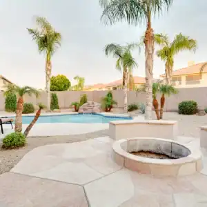 A backyard with concrete pavers installed with a fire pit